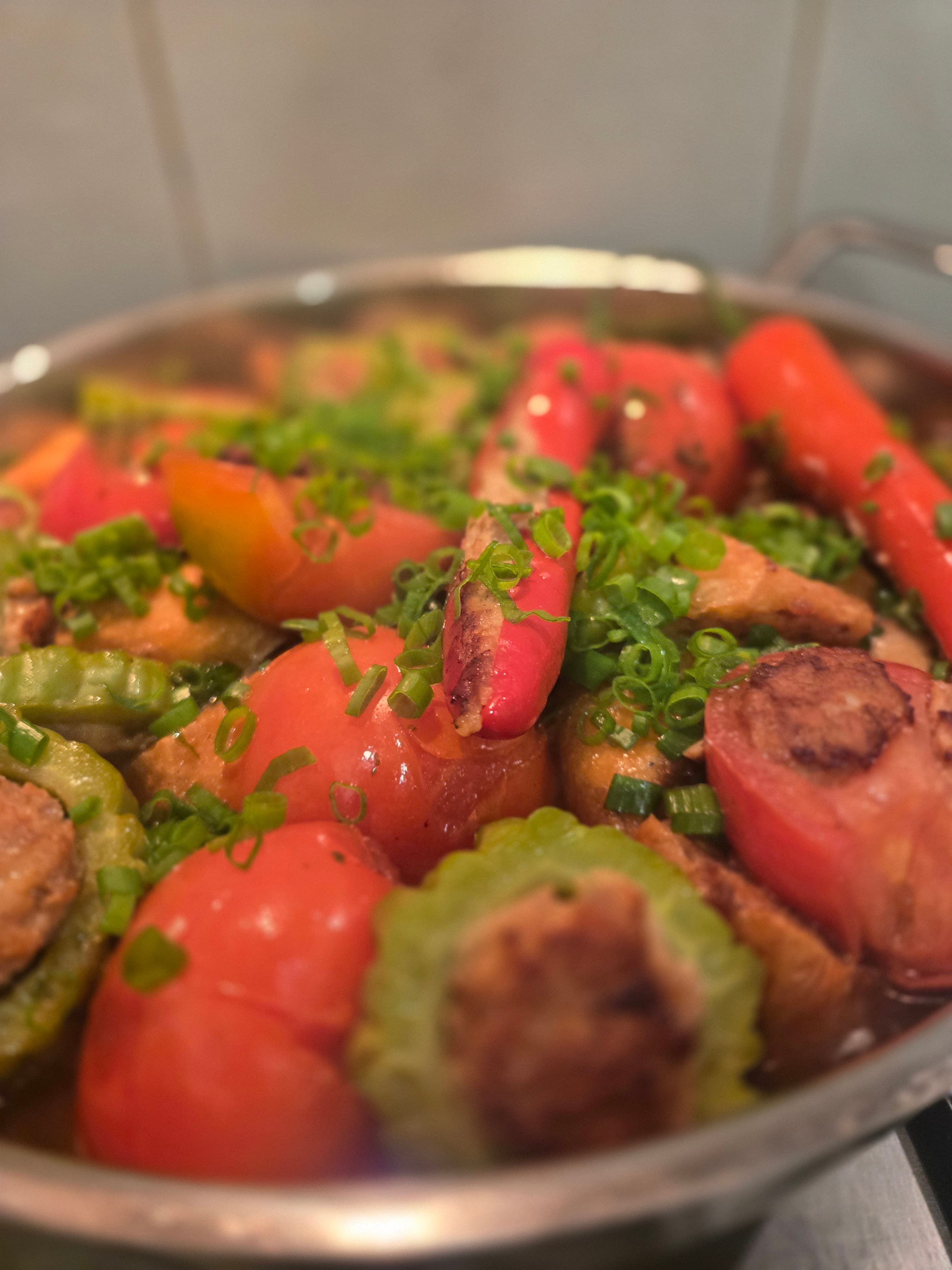 Finished yong tau foo: golden-seared stuffed vegetables in a clear braising stock with spring onion